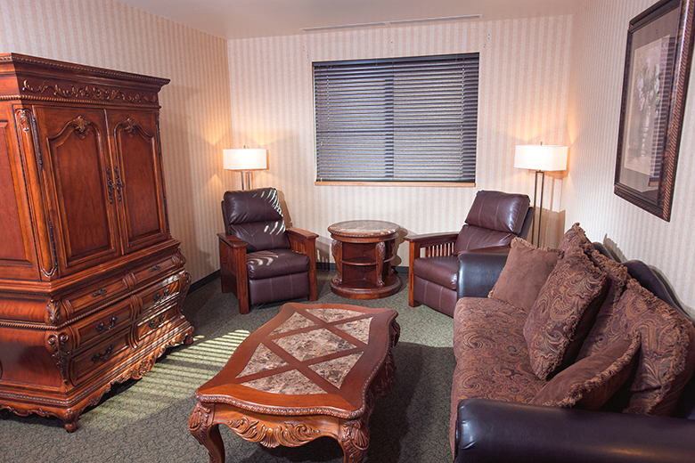 Suite room showing 2 chairs, couch, chest and coffee table