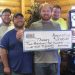 Group of people holding large check