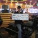 Person holding large check sitting on Indian Chief Motorcycle