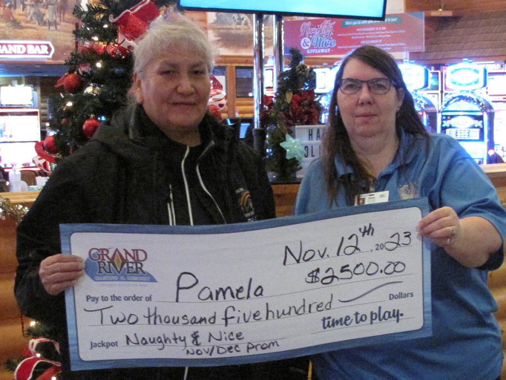 Two people holding a large check