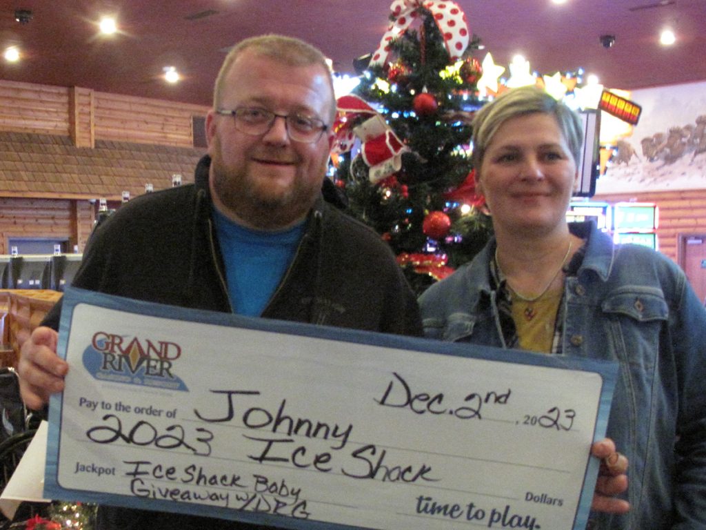 Two people holding a large check
