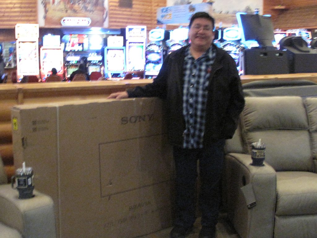 Man standing next to prize of TV box