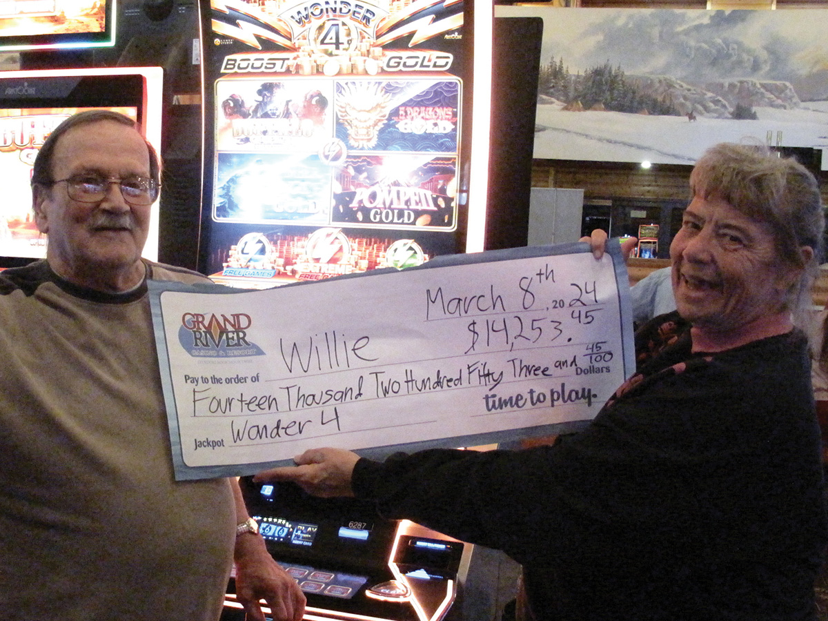 Two people holding large winner check